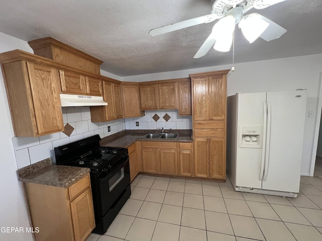 kitchen featuring white refrigerator with ice dispenser, light tile flooring, backsplash, black range with gas stovetop, and ceiling fan