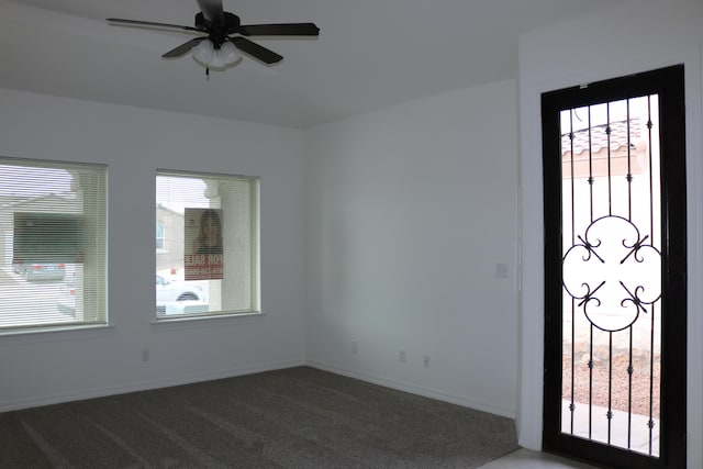 carpeted spare room featuring plenty of natural light and ceiling fan