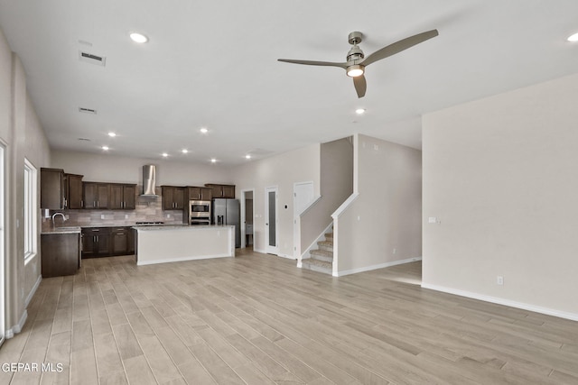 unfurnished living room with light hardwood / wood-style floors, ceiling fan, and sink