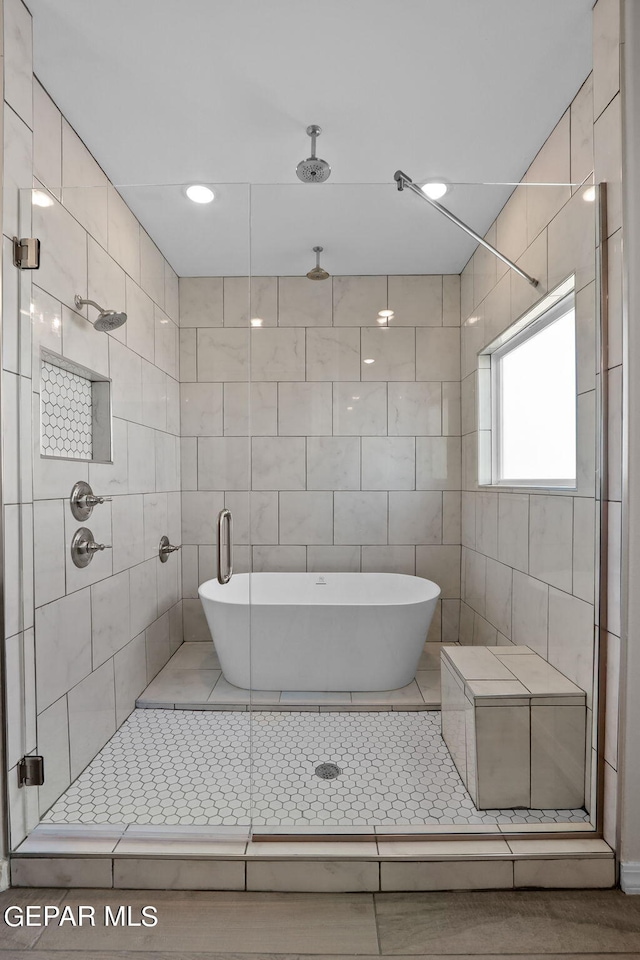 bathroom with tile floors, shower with separate bathtub, and tile walls