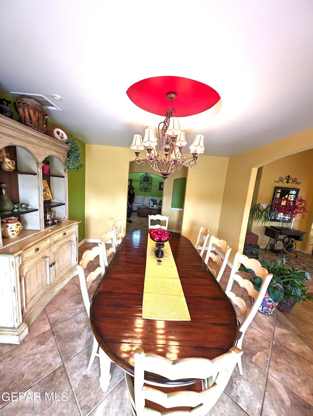 tiled dining space with a chandelier