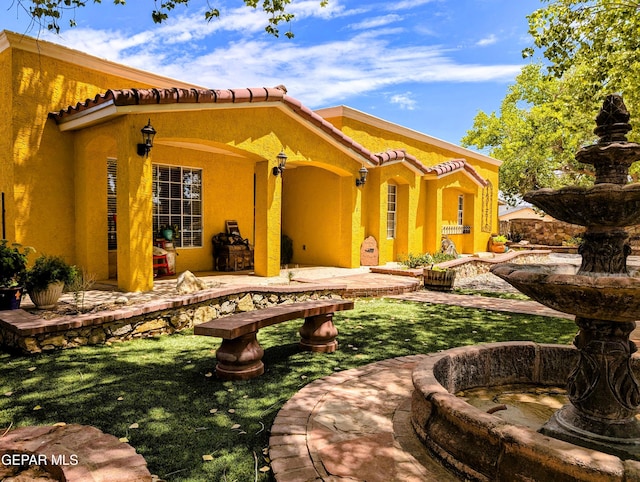 rear view of house with a patio and a lawn