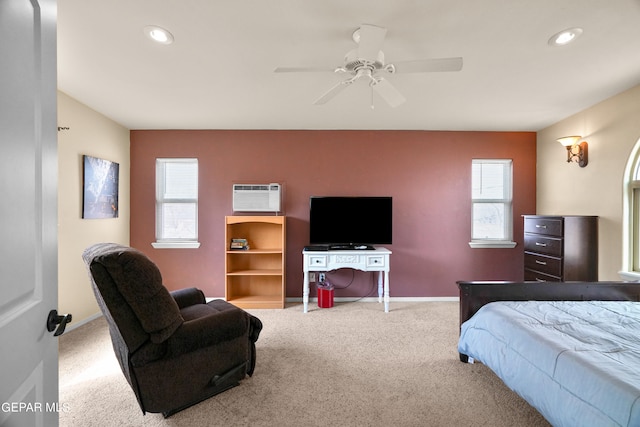 carpeted bedroom with an AC wall unit, ceiling fan, and multiple windows