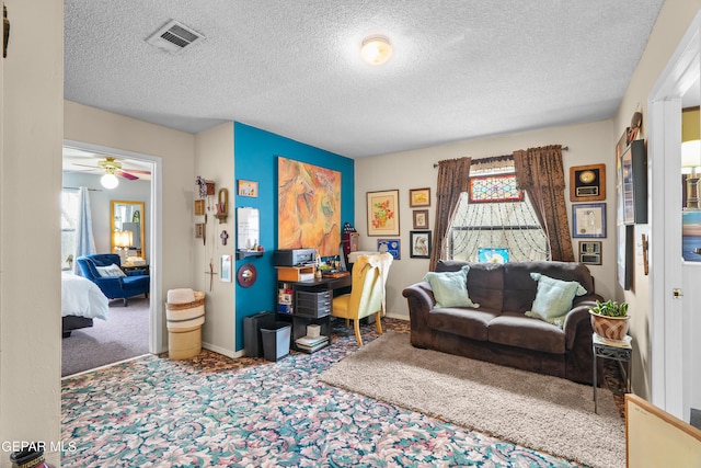 living room with a textured ceiling, ceiling fan, and carpet floors