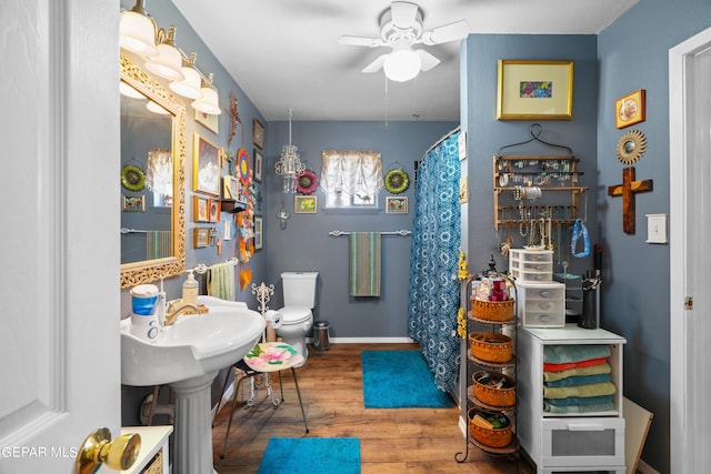 bathroom with hardwood / wood-style floors, ceiling fan, and toilet