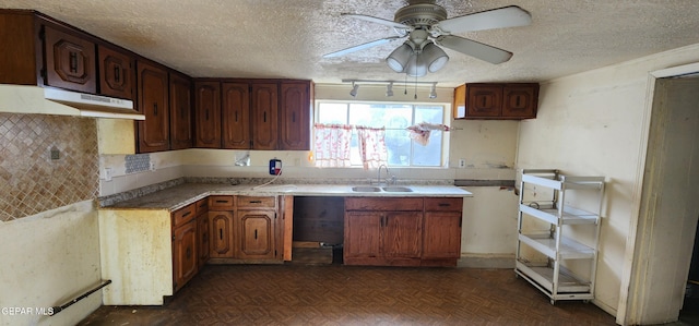 kitchen with a sink, backsplash, a textured ceiling, and ceiling fan