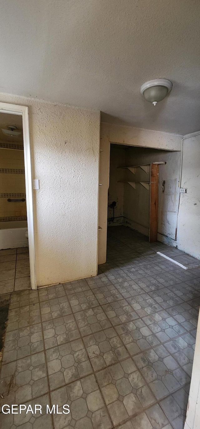 interior space with tile patterned floors and a textured ceiling