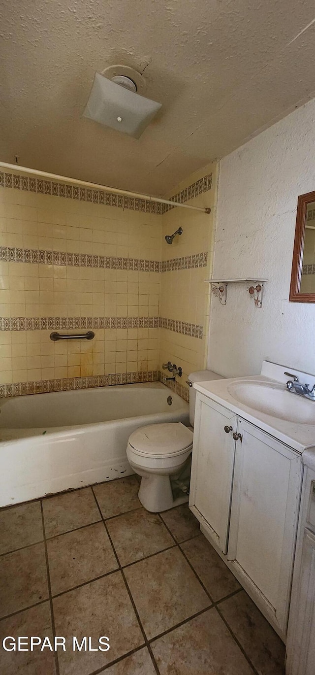 bathroom with toilet, vanity, bathtub / shower combination, tile patterned floors, and a textured ceiling