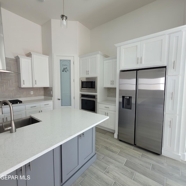 kitchen featuring built in appliances, white cabinetry, and backsplash