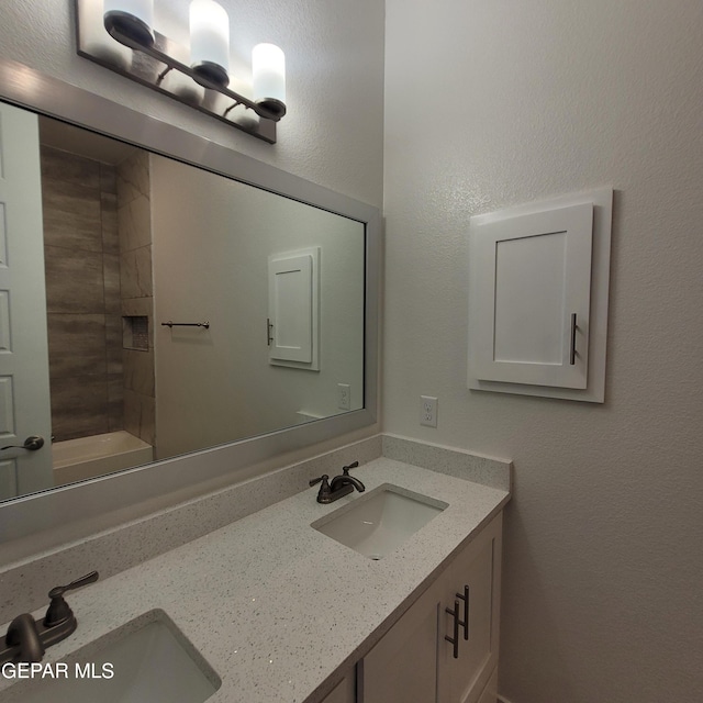 bathroom with vanity and tiled shower / bath