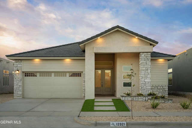 view of front of home with a garage and french doors