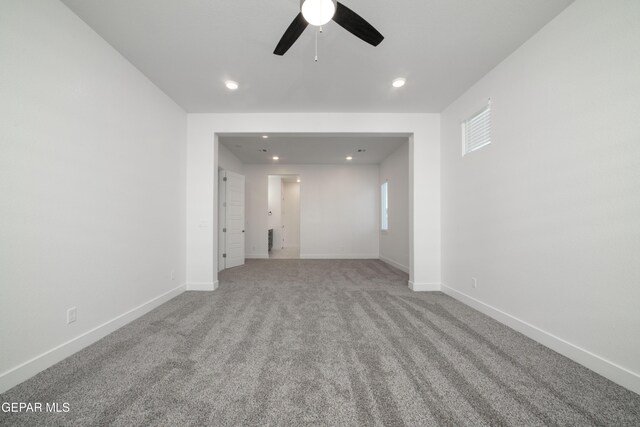 spare room with ceiling fan and light carpet