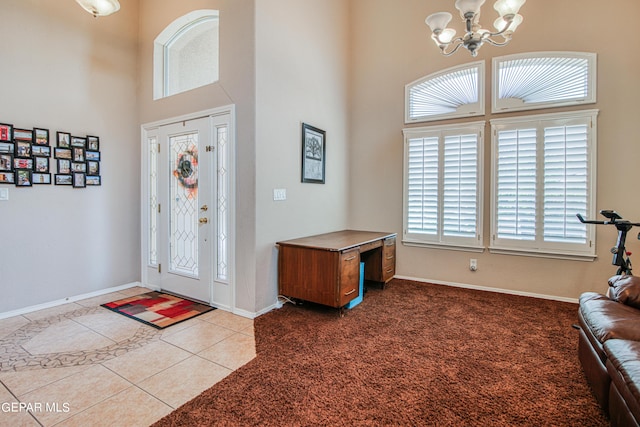 entrance foyer with plenty of natural light, carpet, a high ceiling, and a notable chandelier