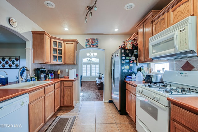 kitchen featuring white appliances, backsplash, and plenty of natural light