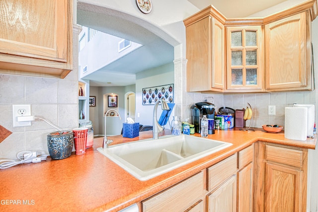 kitchen featuring backsplash, sink, and light brown cabinetry