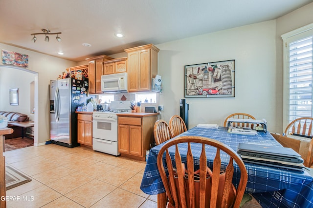 kitchen featuring white appliances, light tile flooring, and track lighting