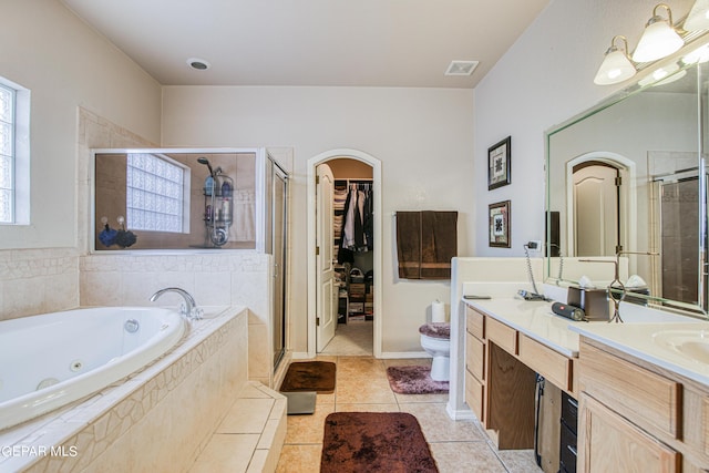 full bathroom featuring dual bowl vanity, toilet, tile floors, and independent shower and bath