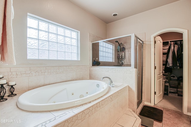 bathroom featuring tile flooring and separate shower and tub