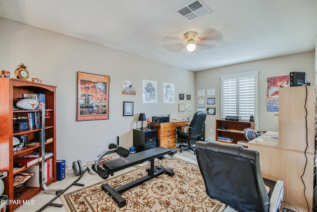 office space with a textured ceiling, ceiling fan, and carpet