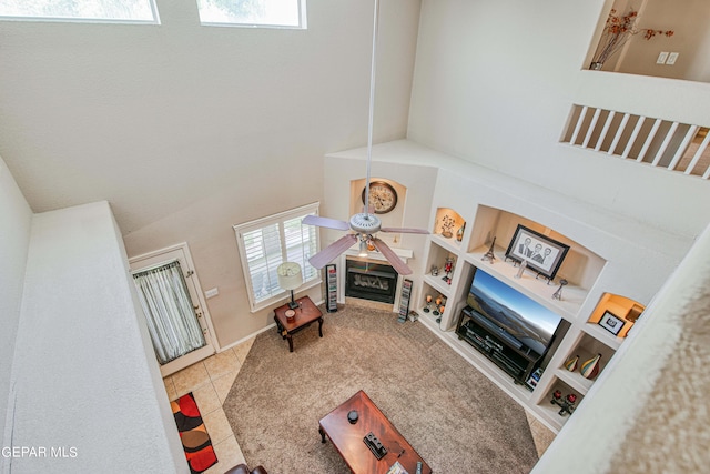 living room featuring tile floors, ceiling fan, and a high ceiling