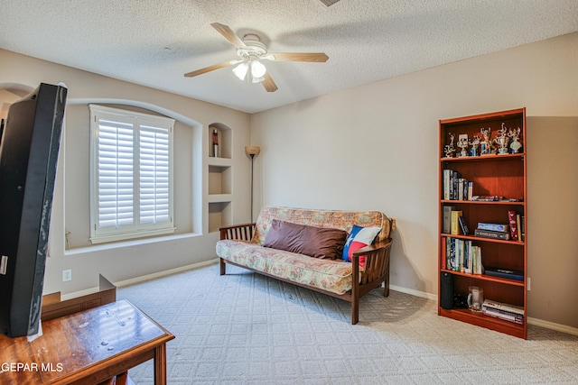 sitting room with carpet, ceiling fan, and a textured ceiling