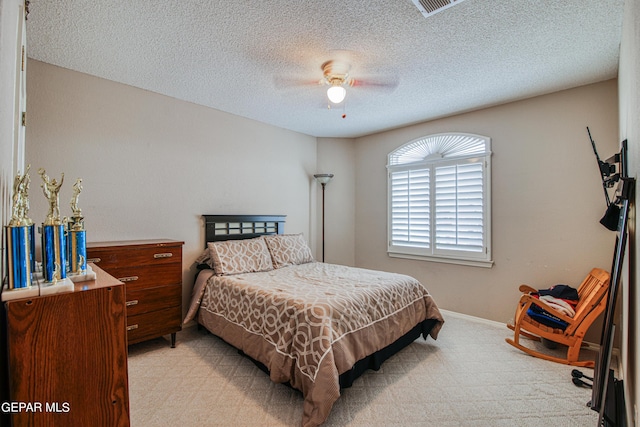 carpeted bedroom with a textured ceiling and ceiling fan