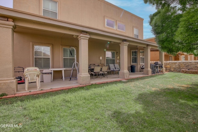 back of house with a patio area, ceiling fan, and a yard