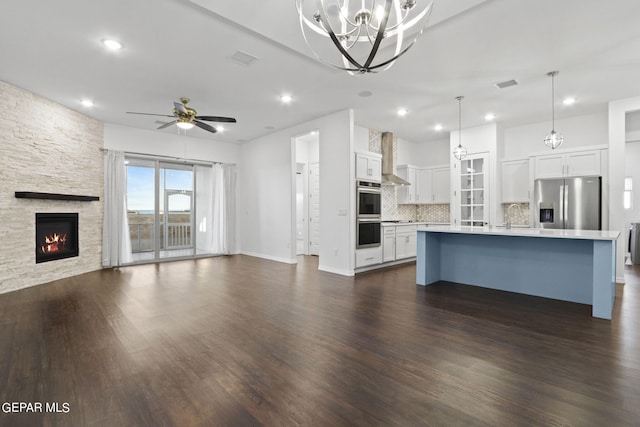 interior space with ceiling fan with notable chandelier, dark hardwood / wood-style flooring, sink, and a fireplace