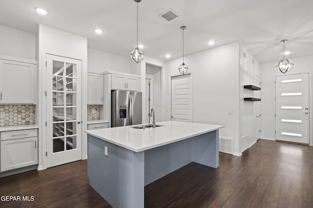 kitchen with hanging light fixtures, backsplash, stainless steel refrigerator with ice dispenser, and dark hardwood / wood-style floors