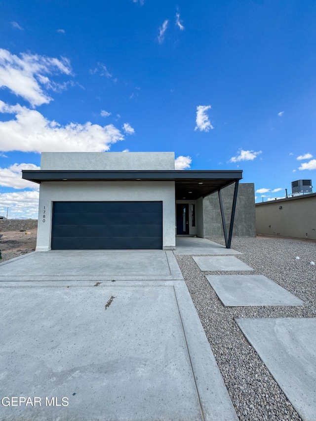 view of front of house with a garage, stucco siding, and driveway