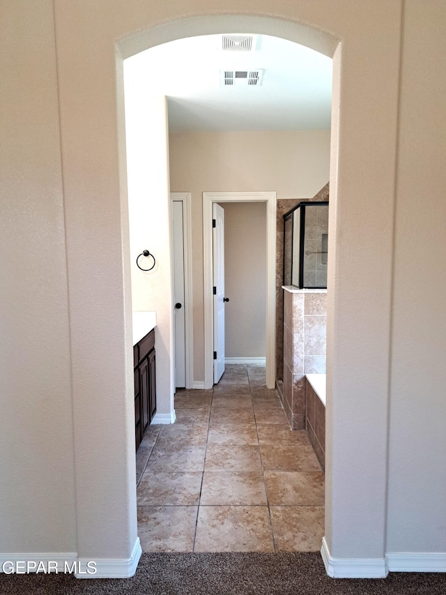 bathroom featuring tile floors, independent shower and bath, and vanity