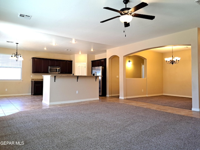 unfurnished living room with light tile floors and ceiling fan with notable chandelier