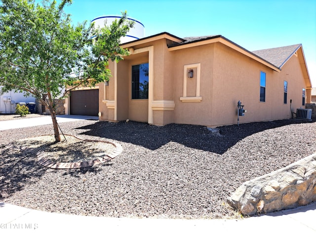 view of front facade with a garage and central air condition unit