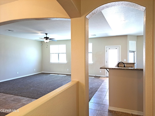 corridor with light colored carpet and a textured ceiling