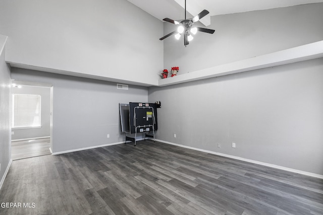 unfurnished living room featuring high vaulted ceiling, ceiling fan, and dark wood-type flooring