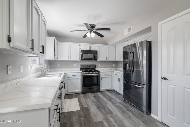 kitchen featuring ceiling fan, sink, white cabinetry, hardwood / wood-style floors, and stainless steel appliances