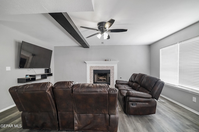 living room featuring beamed ceiling, ceiling fan, and hardwood / wood-style flooring