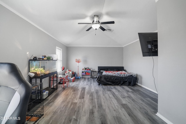 bedroom with vaulted ceiling, ceiling fan, crown molding, and hardwood / wood-style flooring