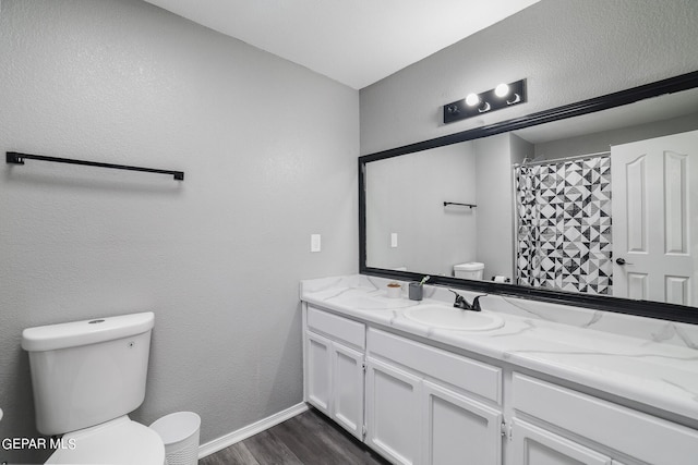 bathroom featuring hardwood / wood-style flooring, toilet, and vanity