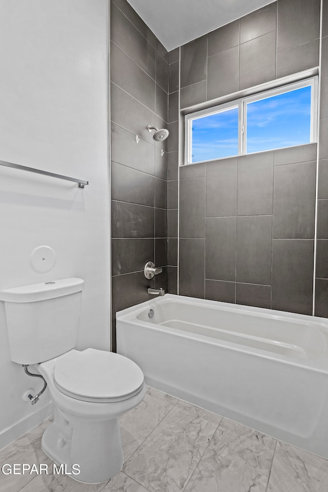 bathroom featuring tile flooring, tiled shower / bath combo, and toilet