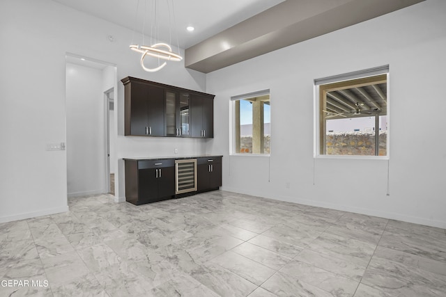 unfurnished living room featuring beverage cooler, light tile flooring, and an inviting chandelier