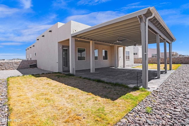 rear view of property featuring a lawn and a patio