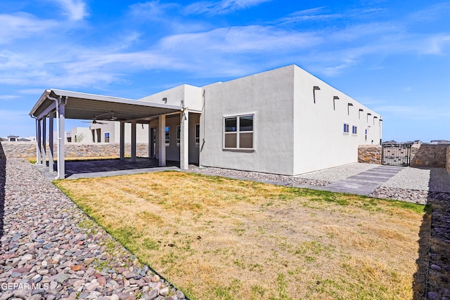 rear view of property featuring a patio area, ceiling fan, and a lawn