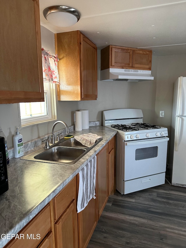 kitchen with white appliances, sink, and dark wood-type flooring