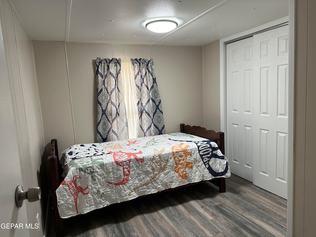 bedroom with a closet, a textured ceiling, and wood-type flooring