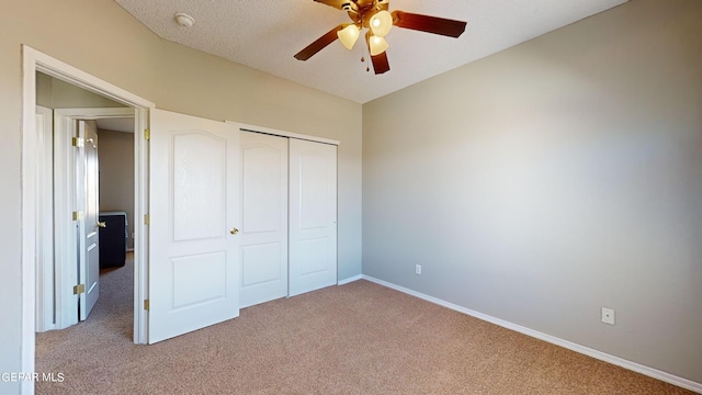 unfurnished bedroom with a textured ceiling, a closet, carpet floors, and ceiling fan