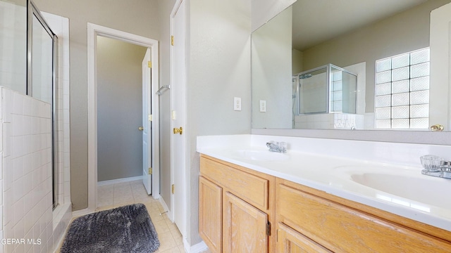 bathroom featuring tile floors, walk in shower, vanity with extensive cabinet space, and double sink