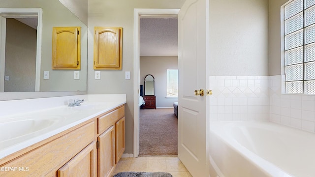 bathroom with a tub, a textured ceiling, tile floors, and vanity