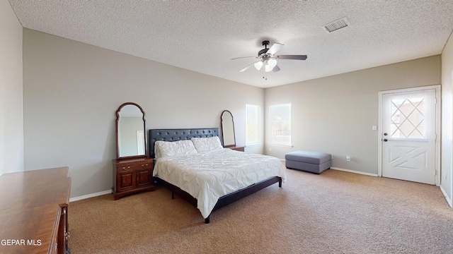 bedroom featuring carpet, ceiling fan, and a textured ceiling