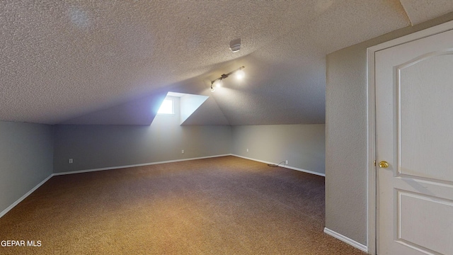 additional living space with a textured ceiling, lofted ceiling, and carpet floors